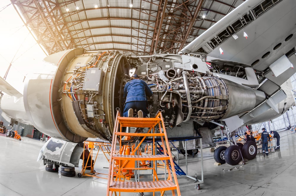 Specialist mechanic repairing large engine of an aircraft